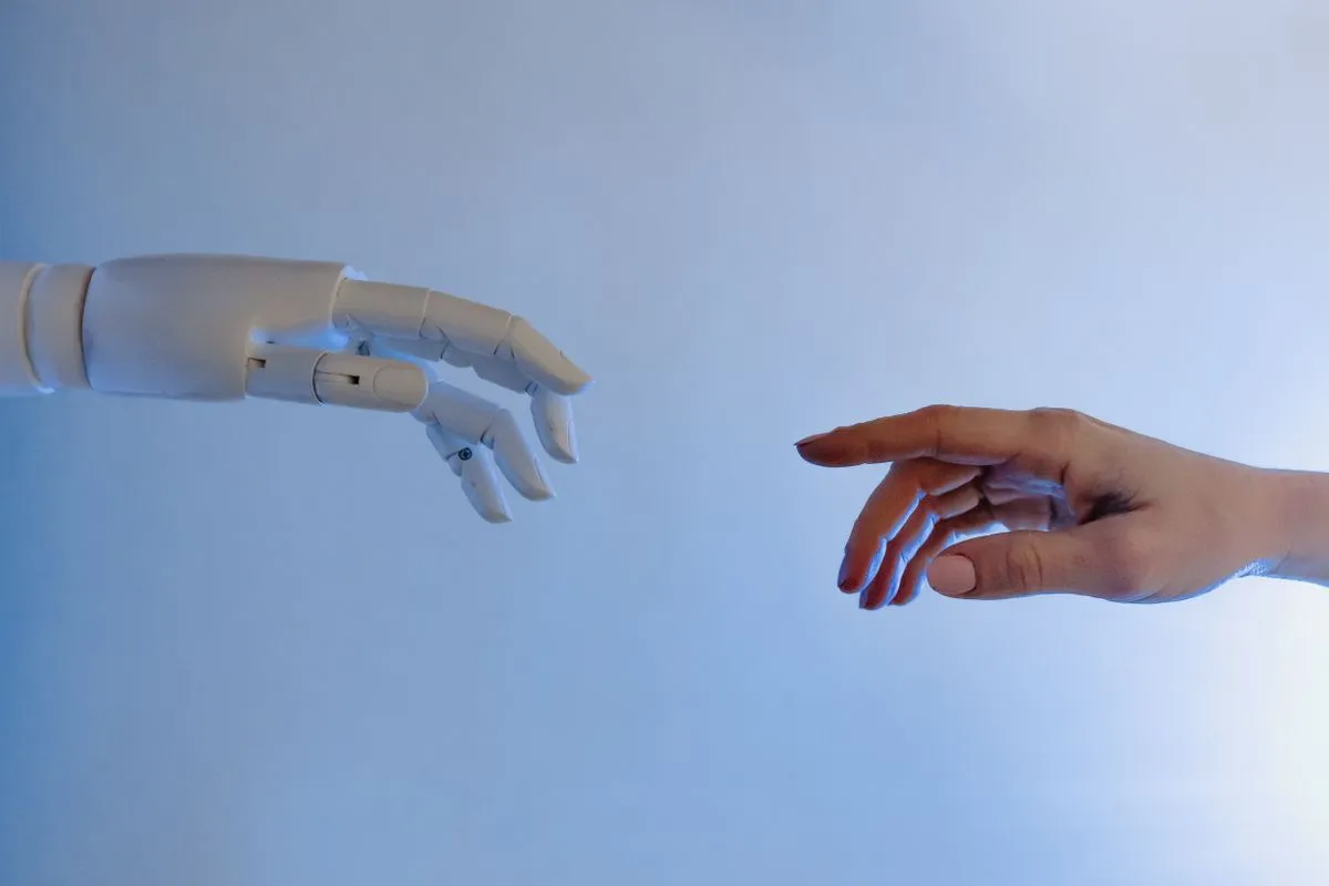 A robot hand and a human hand reaching toward each other